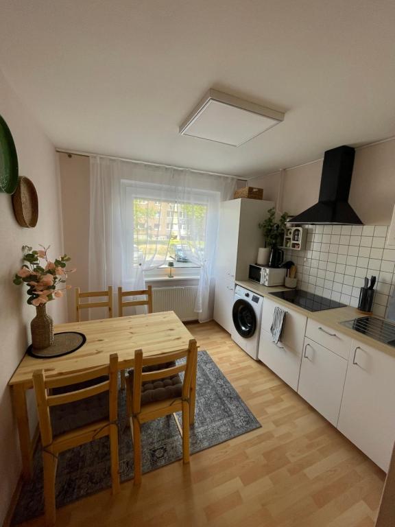 a kitchen with a wooden table and a dining room at 3 kambarių butas pirmame aukšte in Mažeikiai