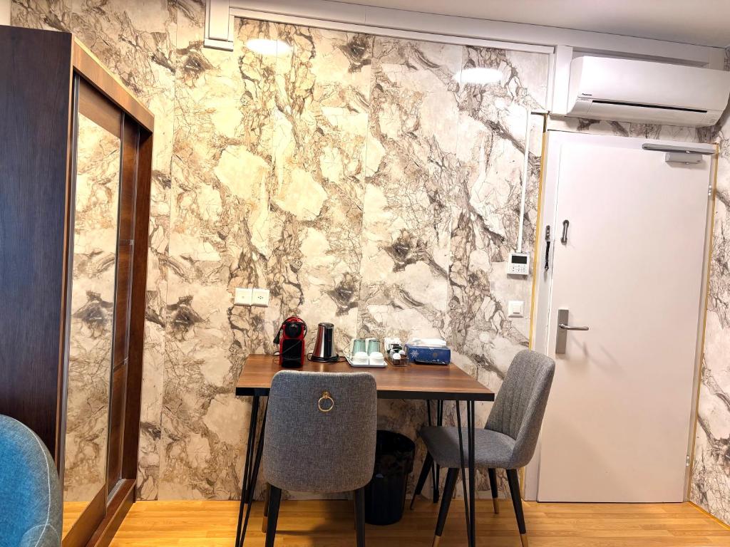 a dining room with a table and chairs against a stone wall at Akomo Bern in Bern
