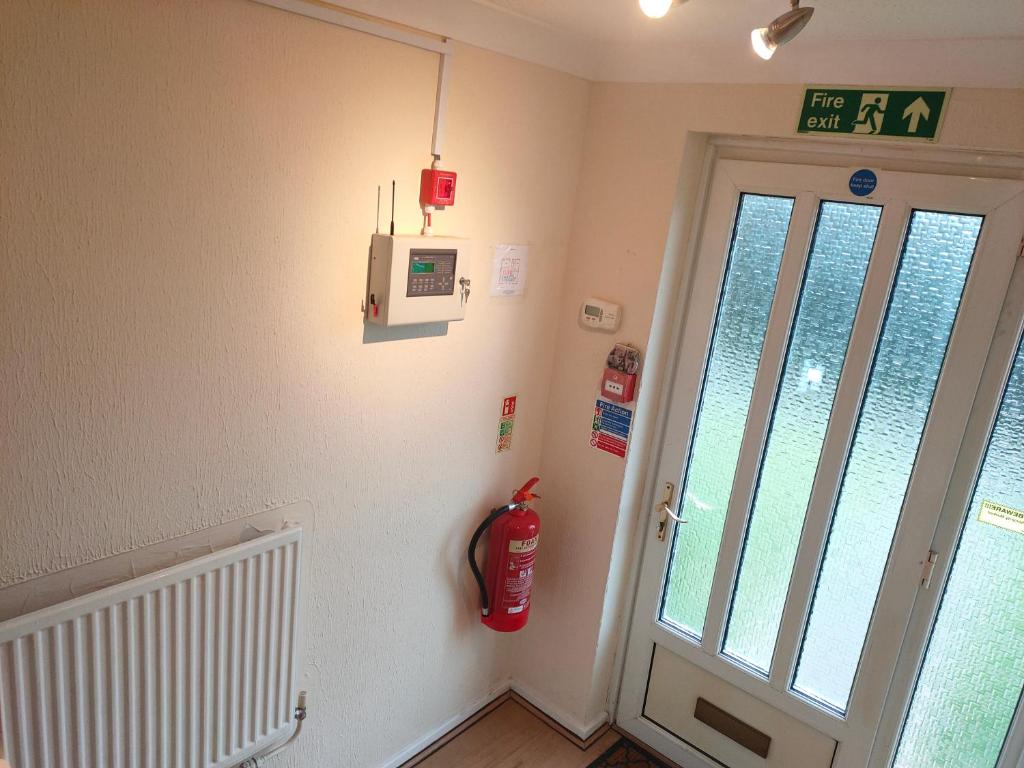 a room with a fire hydrant on the wall next to a door at Comfortable holiday home in Basildon Essex in Laindon