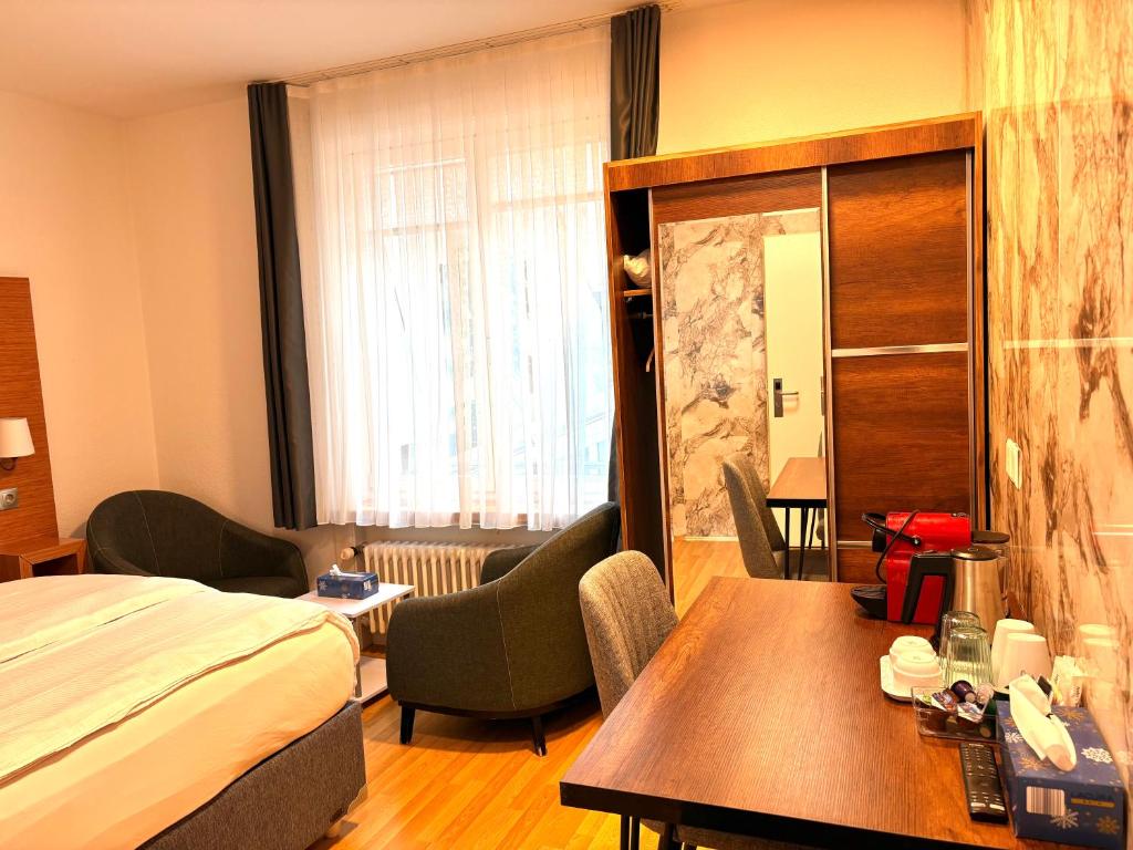 a hotel room with a bed and a table at Akomo Bern in Bern