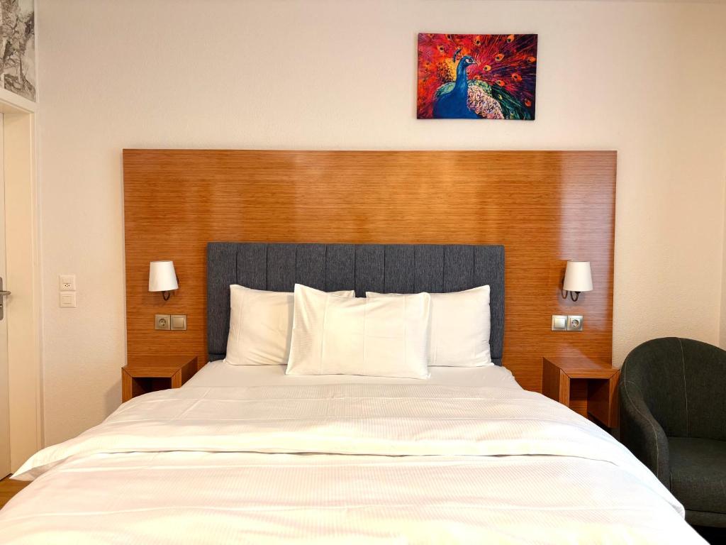 a bedroom with a large white bed with a wooden headboard at Akomo Bern in Bern