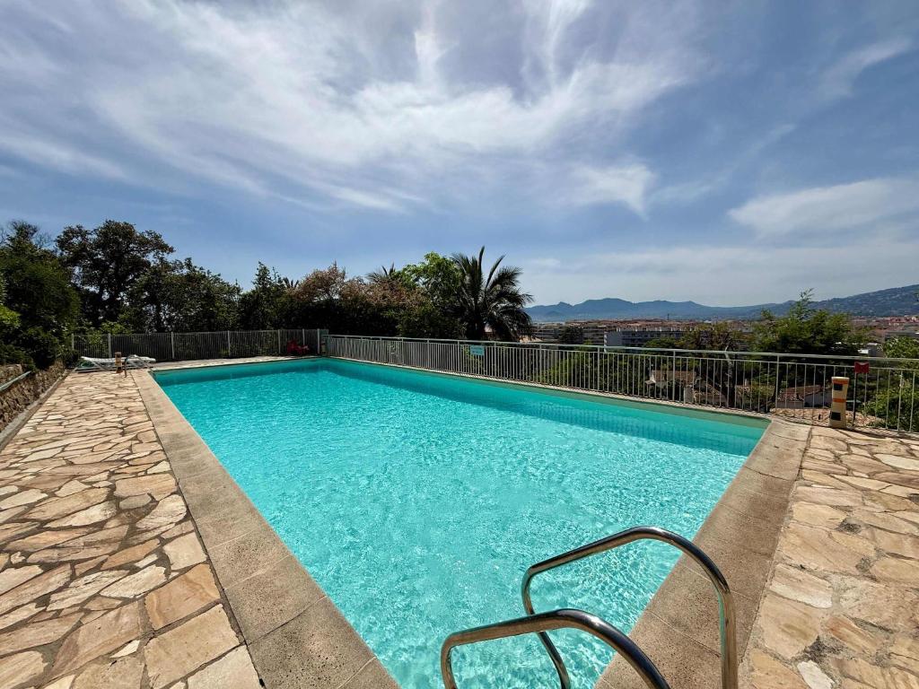 une piscine d'eau bleue et une clôture dans l'établissement B084-Confort et serenite piscine et stationnement, à Cannes