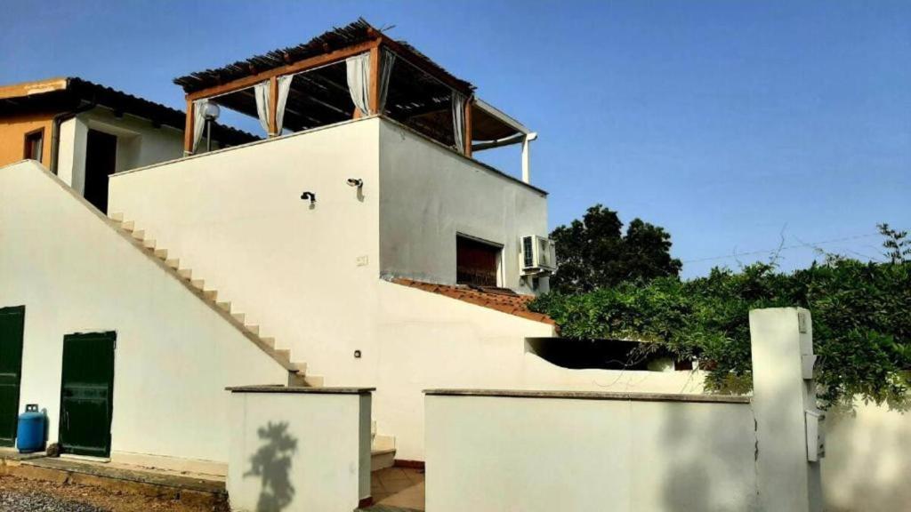 a white house with a staircase on top of it at Domo Marzellinu in Orosei
