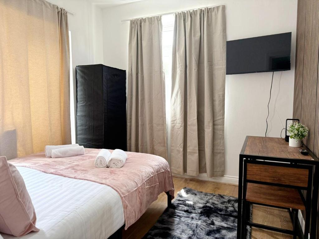 a bedroom with a bed and a desk and a window at BD-Stylish Double bed in Wembley in London