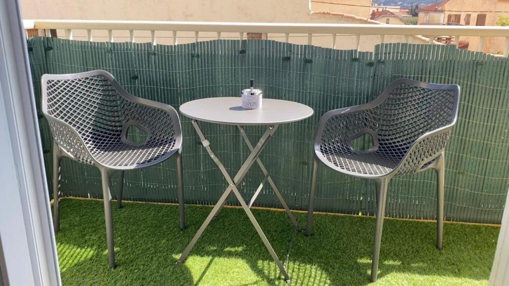 2 chaises et une table avec une bougie sur le balcon dans l'établissement Appartement t3, à La Seyne-sur-Mer