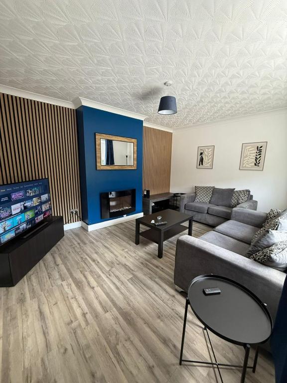 a living room with a couch and a tv at Braemar House - 3 Bedroom, Sleeps 5 in Stockton-on-Tees
