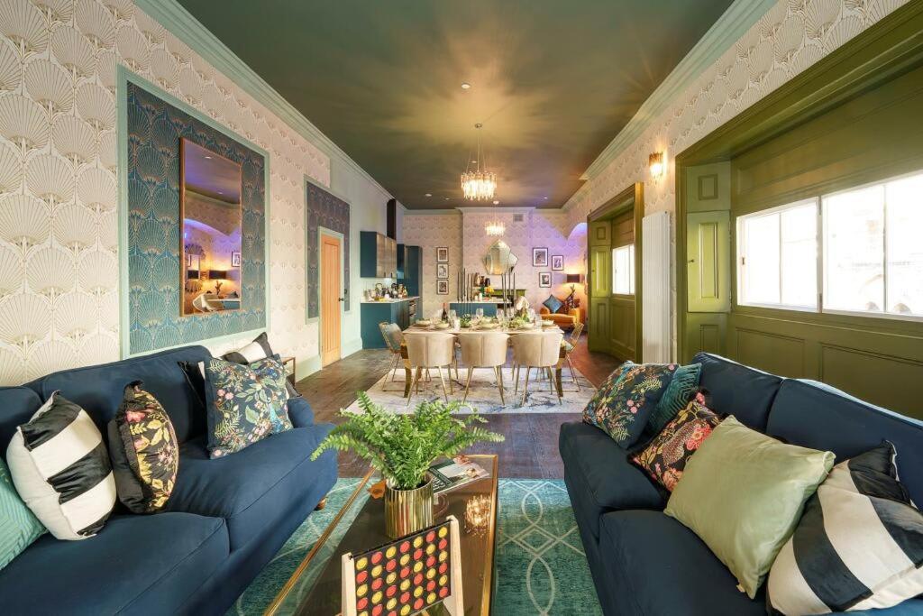 a living room with a blue couch and a table at The Royal Mint apartment at The Bank of England in Bristol