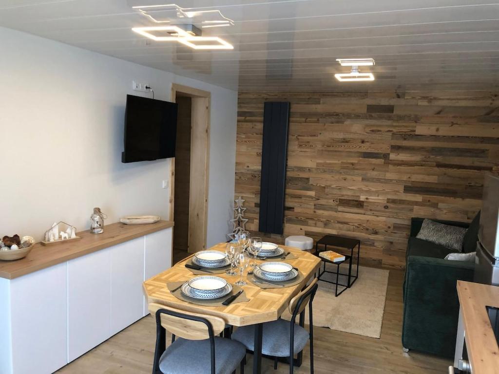 une salle à manger avec une table et des chaises en bois dans l'établissement L'Appart', à Chambon-sur-Lac