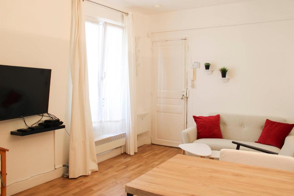un salon avec un canapé et une télévision dans l'établissement Beautiful cocoon of love - near park, à Paris