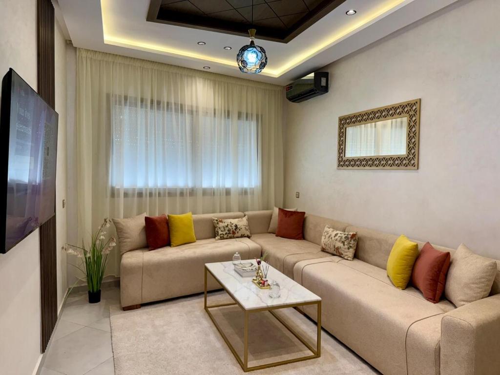 a living room with a couch and a table at Chic & Bright Apartment in Kenitra