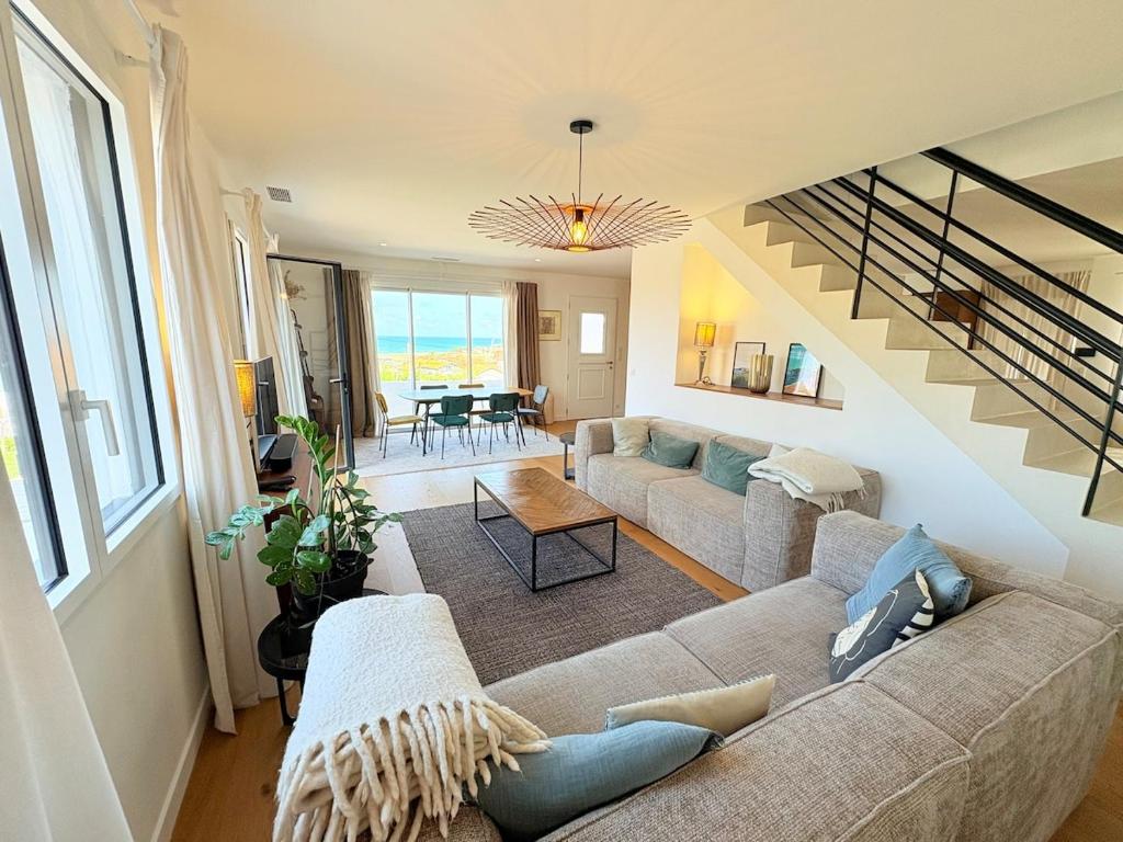 un salon avec un canapé et un escalier dans l'établissement Bidart - Modern house - Ocean view - beach, à Bidart