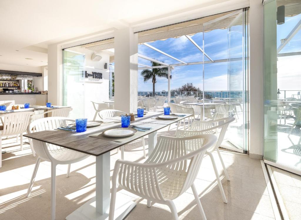 a dining room with a table and chairs with a view of the ocean at Hotel Ocean House Costa del Sol, Affiliated by Meliá in Torremolinos