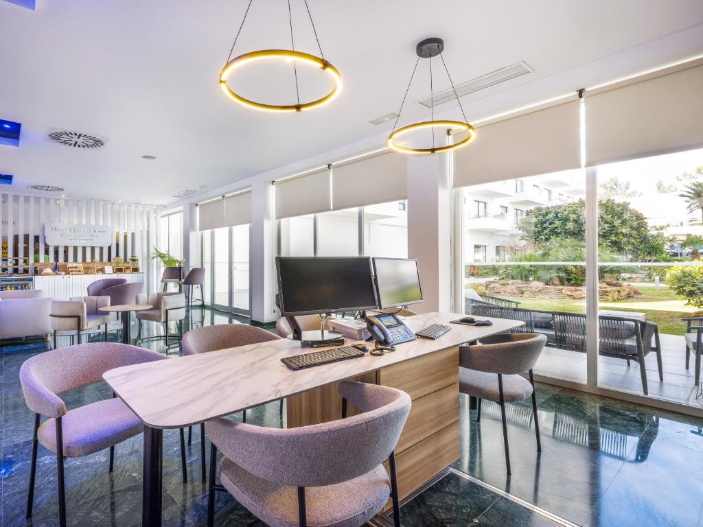 an office with a desk with a computer and chairs at Hotel Ocean House Costa del Sol, Affiliated by Meliá in Torremolinos