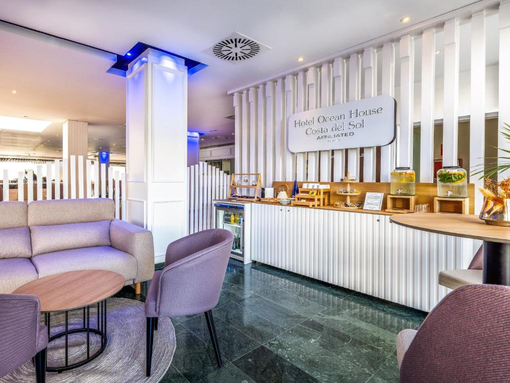 a restaurant with a couch and tables and chairs at Hotel Ocean House Costa del Sol, Affiliated by Meliá in Torremolinos