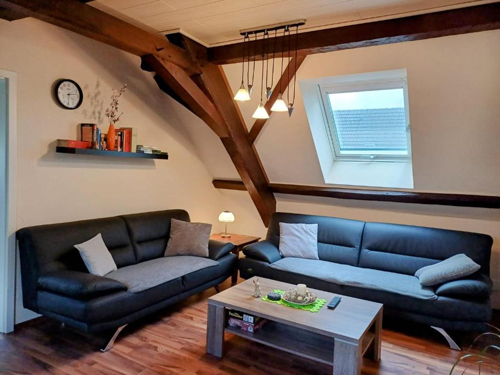 a living room with two couches and a table at Ferienwohnung Katharina in Laufeld
