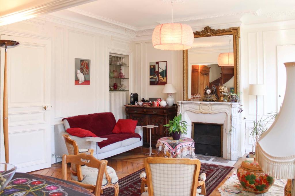 - un salon avec un canapé rouge et une cheminée dans l'établissement Family duplex - with balcony, à Paris