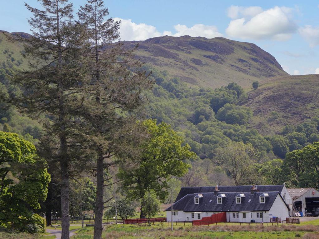 une maison blanche devant une montagne dans l'établissement North Cottage, à Glenelg
