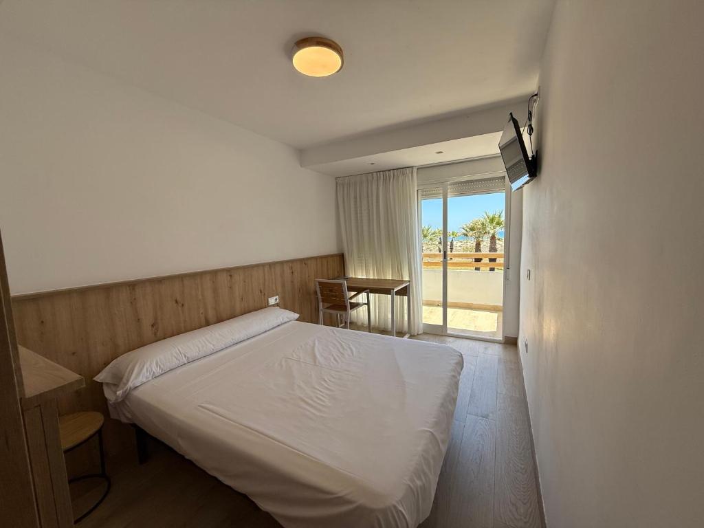A bed or beds in a room at Pensión La Ola