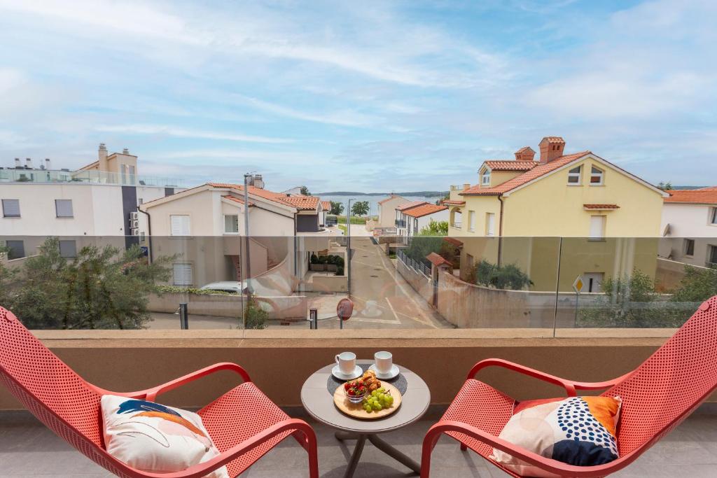 メドゥリンにあるLuxury apartment near the beachのバルコニー(椅子2脚、テーブル、食器付)