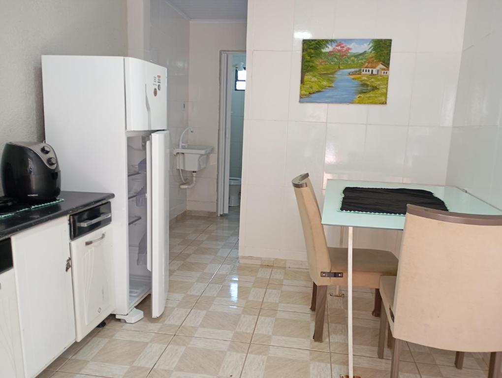 a small kitchen with a table and a refrigerator at Kit pequeno espaco popular in Riacho Fundo