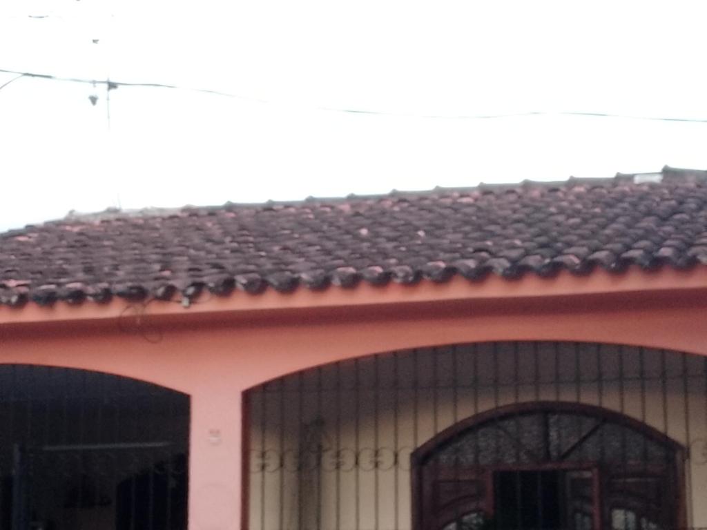 ein rosa Haus mit einem schwarzen Dach und einem Fenster in der Unterkunft Evsam in Belém