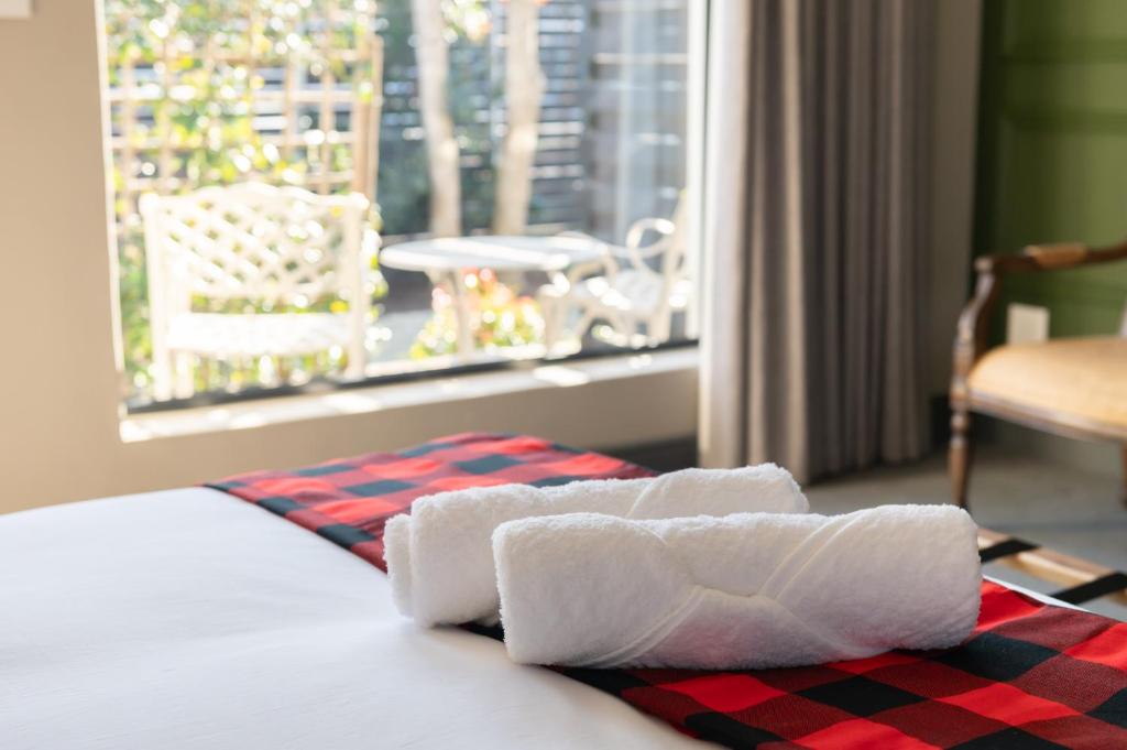 a pair of towels on a bed with a window at Blix Inn Guesthouse in Stellenbosch