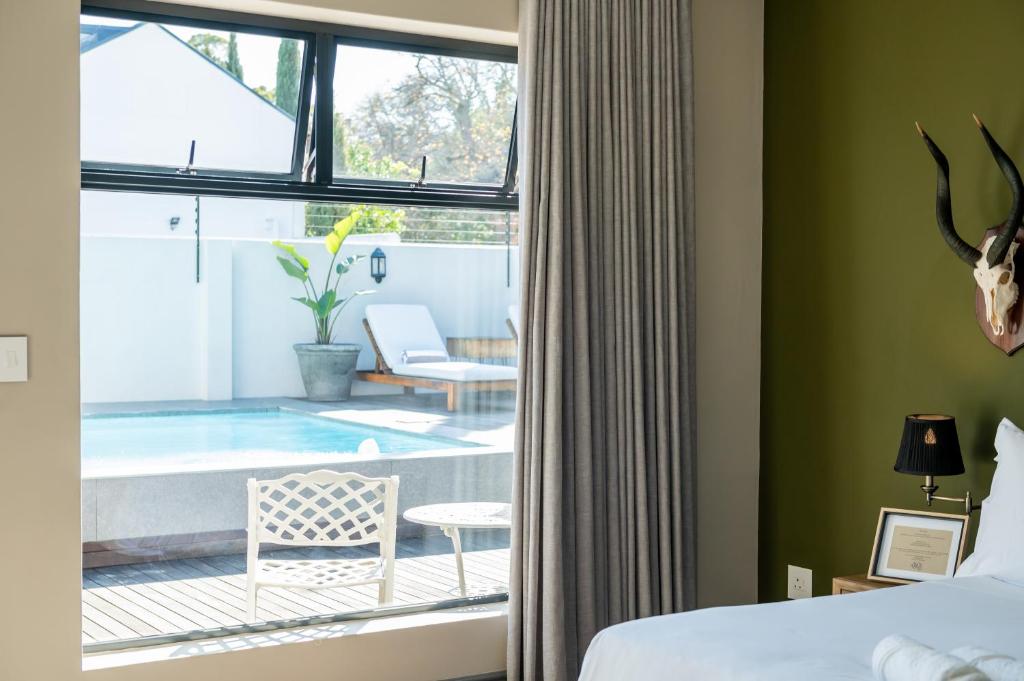 a bedroom with a bed and a view of a pool at Blix Inn Guesthouse in Stellenbosch