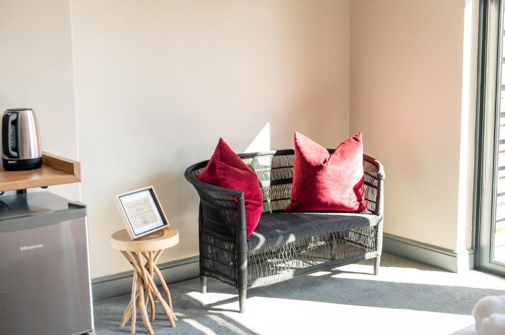 a black chair with red pillows in a living room at Blix Inn Guesthouse in Stellenbosch