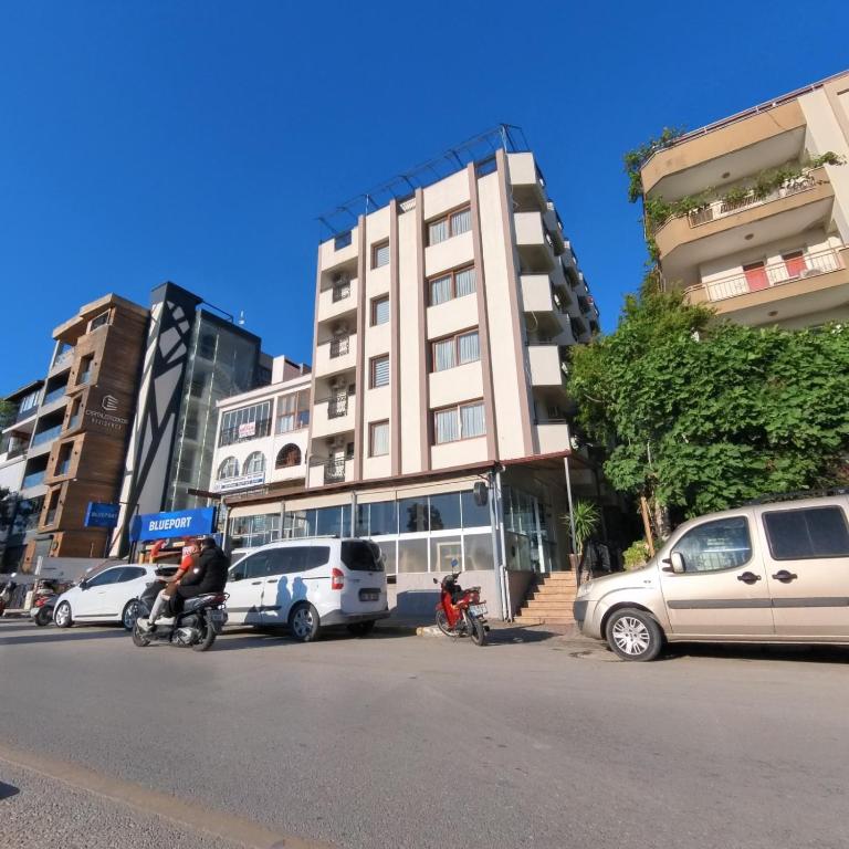 a building with cars parked on the side of a street at Hbs Hotel in Kuşadası