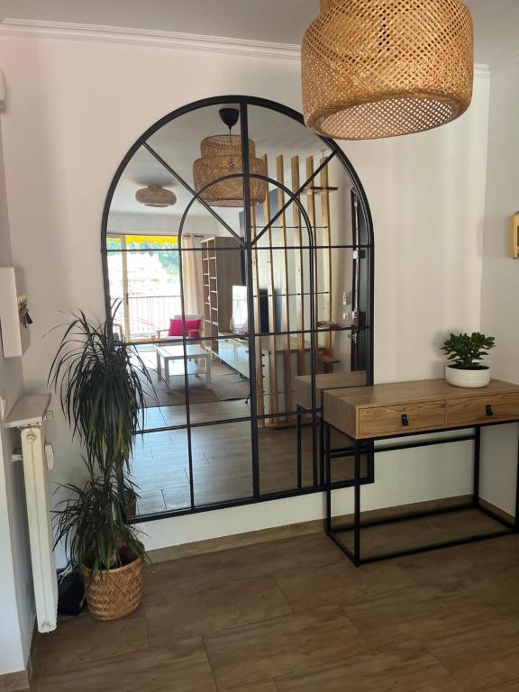 Cette chambre comprend un grand miroir et une table. dans l'établissement Maggie, à Menton