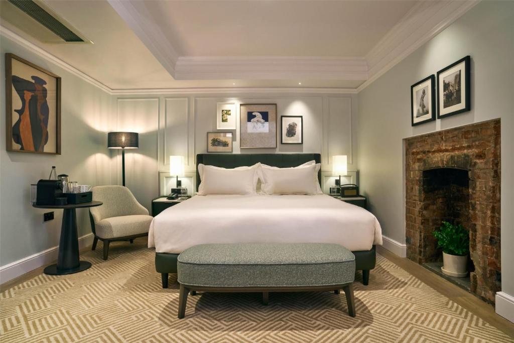 a bedroom with a large bed and a fireplace at Radisson Blu Hotel, London Bloomsbury in London