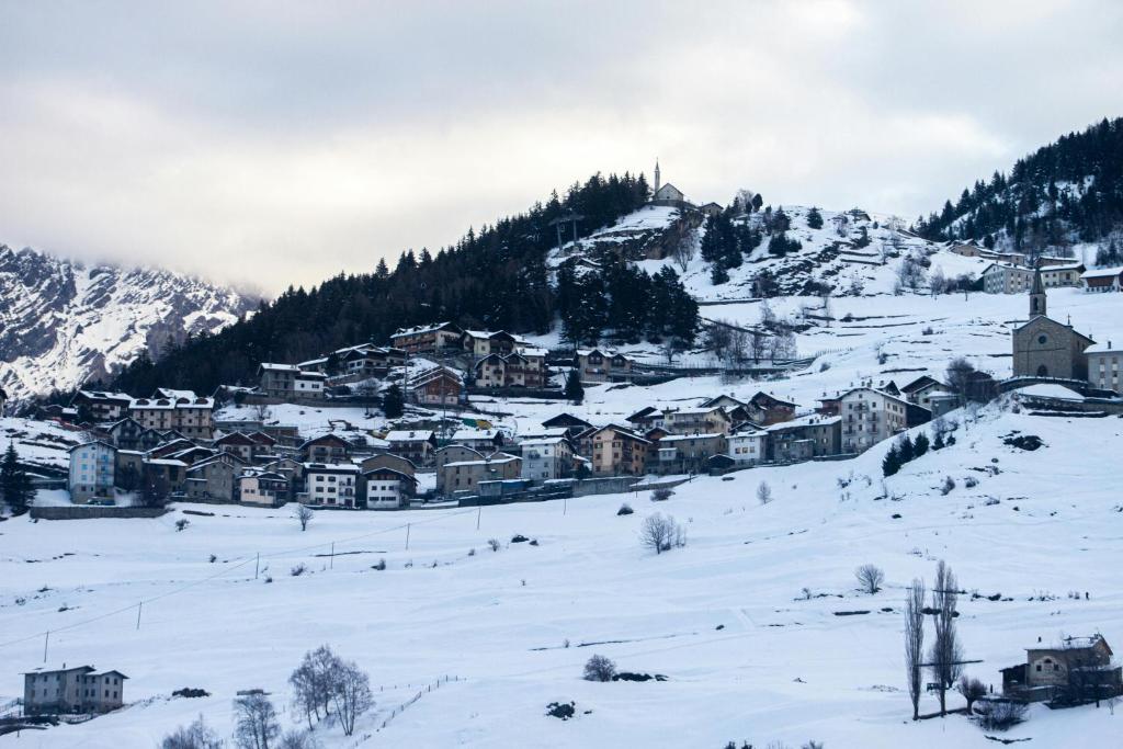 a village covered in snow on a mountain at HOTIDAY Bormio Apartments in Bormio