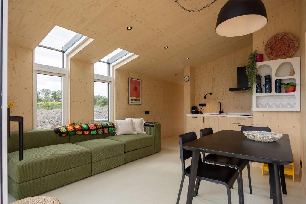 un soggiorno con un divano verde e un tavolo di Hello Zeeland - Tiny House Zeeuwse Liefde 16 a Westkapelle