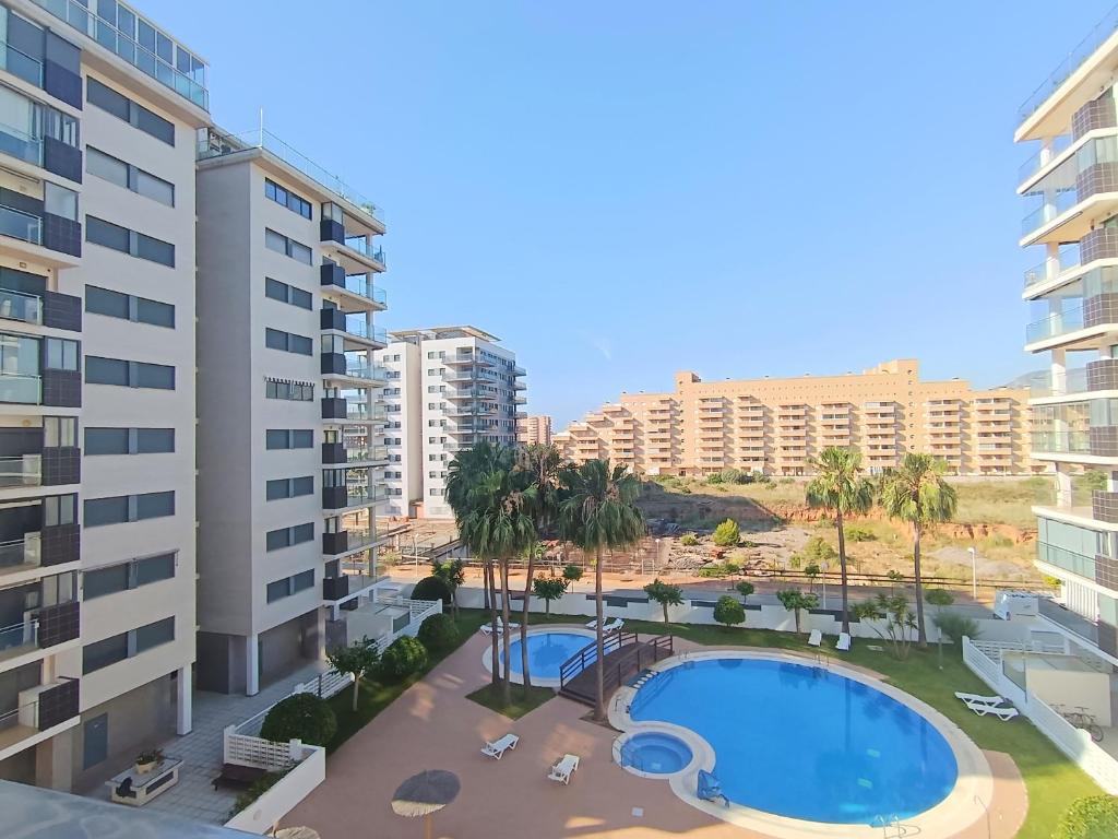 einen Blick über den Pool vor den Gebäuden in der Unterkunft Ayf 200m del mar 2 piscinas, pista de padel y gym in Oropesa del Mar