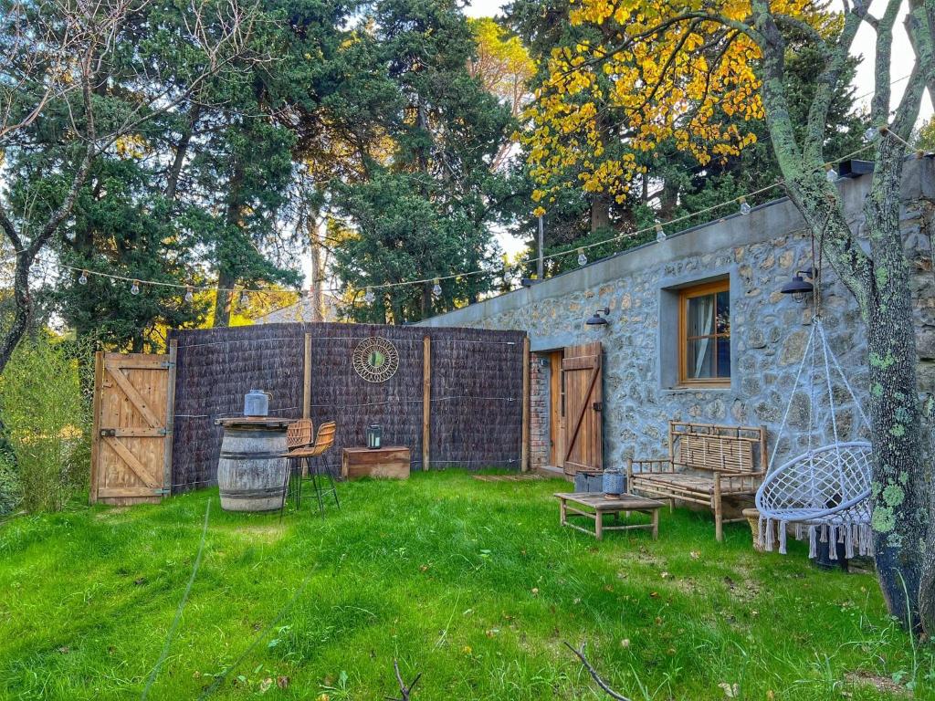 une cour avec une maison en pierre avec une clôture dans l'établissement Samadhi - Gite avec jardin et spa, à Toulon