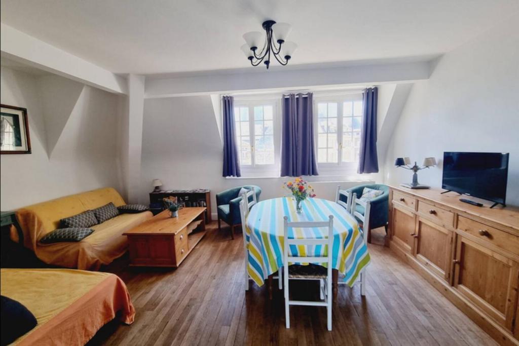 un salon avec une table, des chaises et un canapé dans l'établissement Charming 3 room near the beach of Saint-Malo, à Saint-Malo