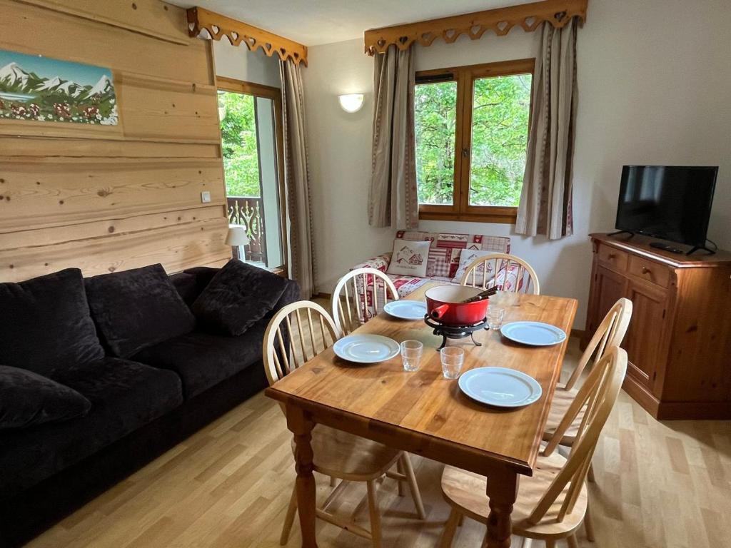 un salon avec une table et des chaises en bois dans l'établissement Charmant 2 Pièces Cabine avec Parking et Balcon - Résidence Le Grand Tétras à Samoëns - FR-1-629-105, à Samoëns
