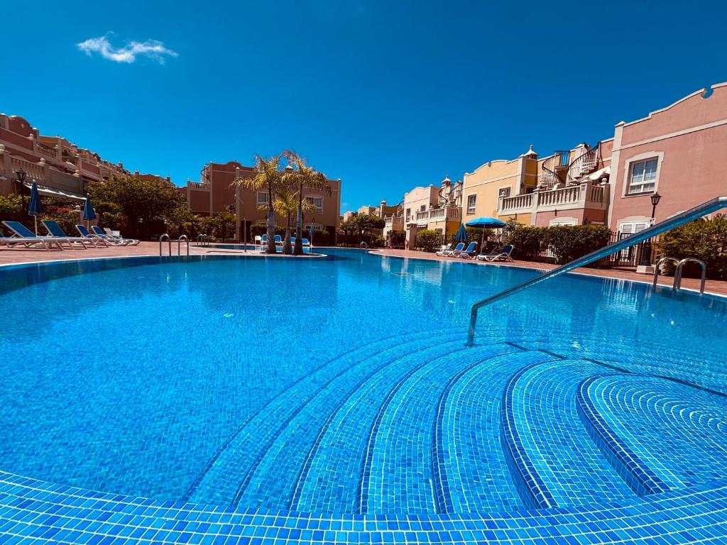 a large blue swimming pool in a city at Paraiso en Palmmar in Palm-mar