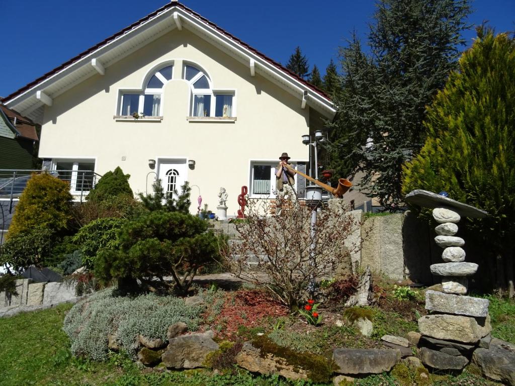 a house with a person sitting on the porch of it at Ferienwohnung Hermannstein in Ilmenau
