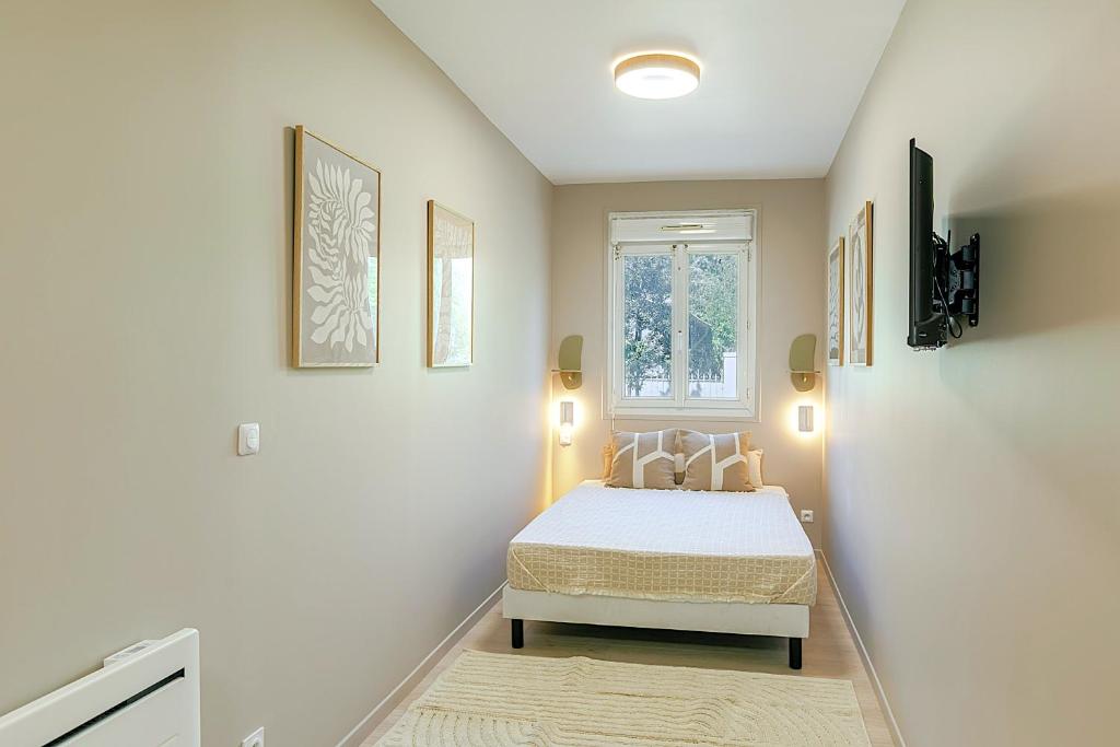 une chambre avec un lit et une fenêtre dans l'établissement Studio idéal pour un séjour reposant, à Asnières-sur-Seine