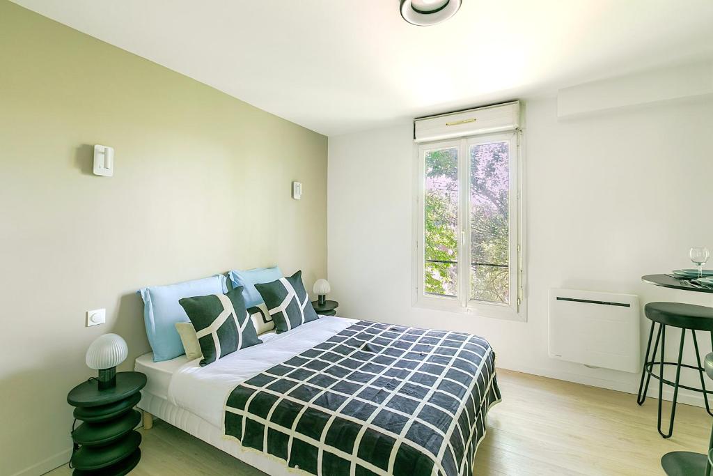 - une chambre avec un lit doté d'oreillers bleus et verts dans l'établissement Studio lumineux à deux pas des commerces- Asnières, à Asnières-sur-Seine