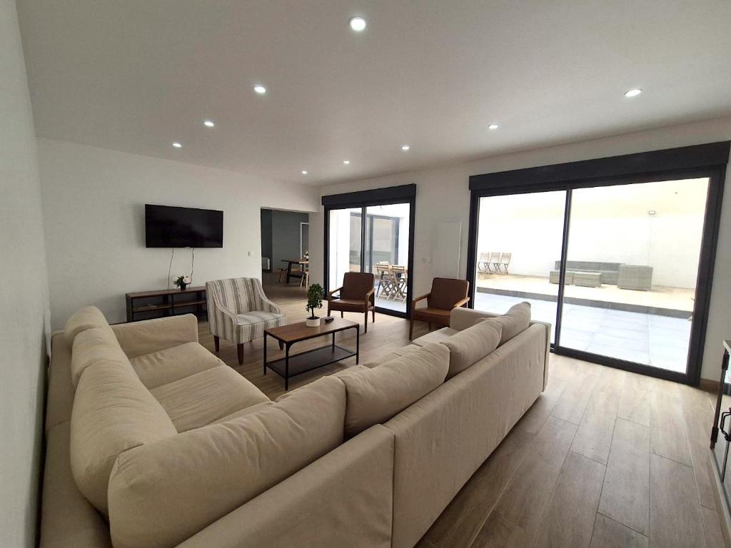 - un salon avec un grand canapé et une télévision dans l'établissement Abu Dhabi, magnifique maison, à Reims