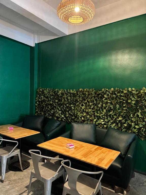 eine grüne Wand mit zwei Tischen und Stühlen in der Unterkunft Green Terrace Residence Phuket in Kathu