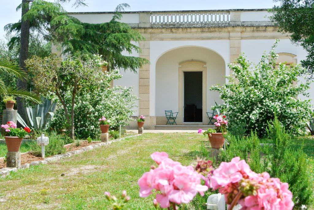 un giardino con fiori rosa di fronte a una casa di Agriturismo Villa Coluccia a Martano