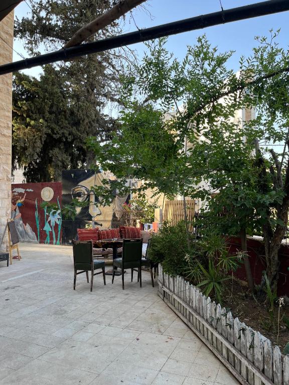 a patio with a table and chairs in a yard at bayt alrahaal in Amman