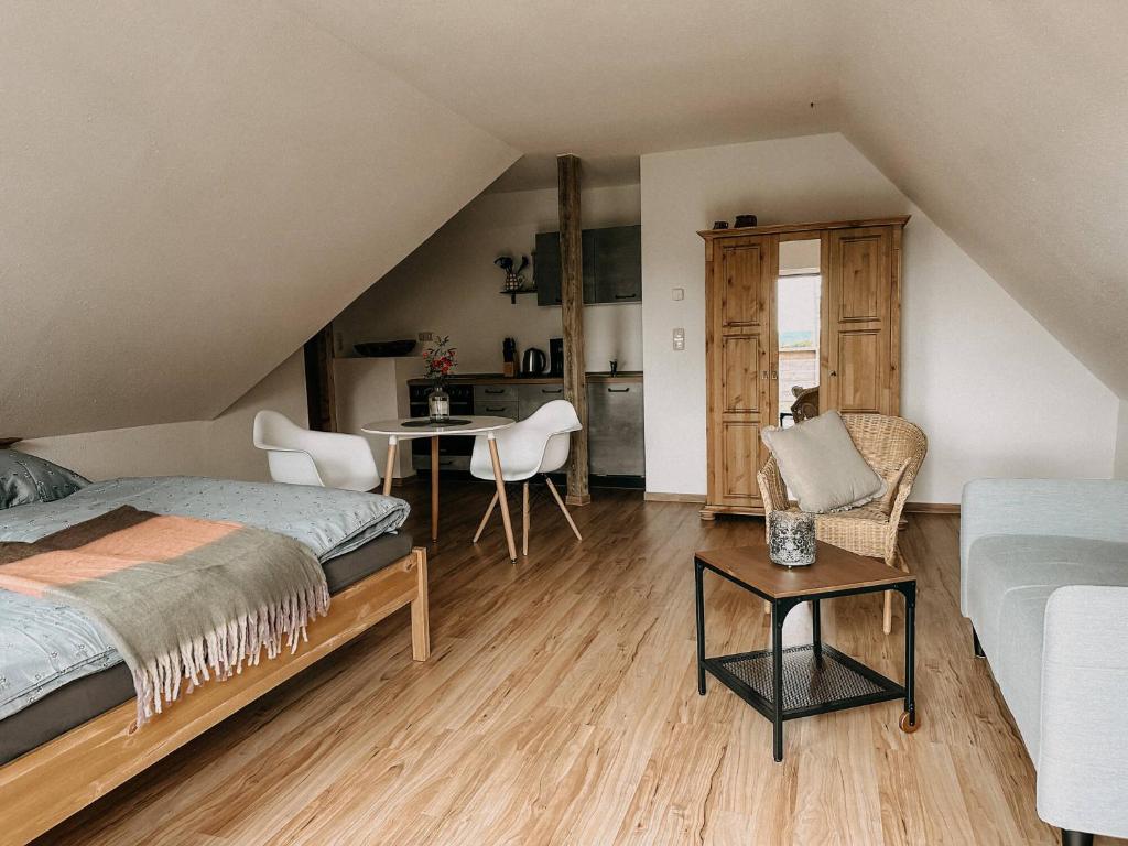 a bedroom with a bed and a table and chairs at Landhaus Bärenstein - Pano-Blick 1 in Bärenstein