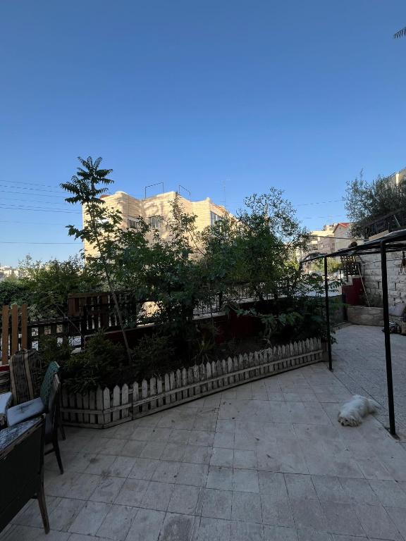 a dog laying on a patio next to a fence at bayt alrahaal in Amman