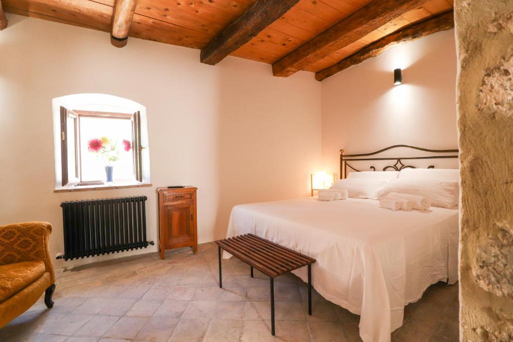 a bedroom with a large white bed and a window at Sasso Bianco - Bagno Hammam - Doccia emozionale in Santo Stefano di Sessanio