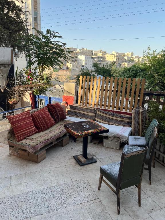 a patio with a couch and a table and chairs at bayt alrahaal in Amman