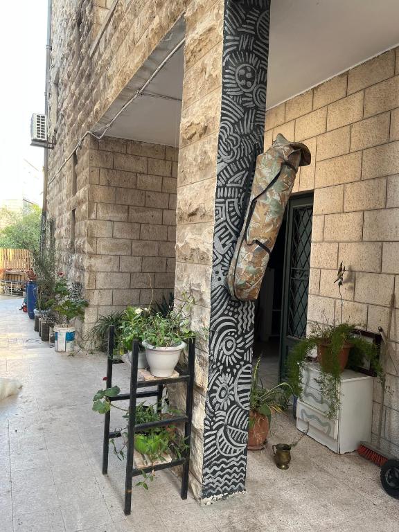 a building with a pillar with a plant at bayt alrahaal in Amman